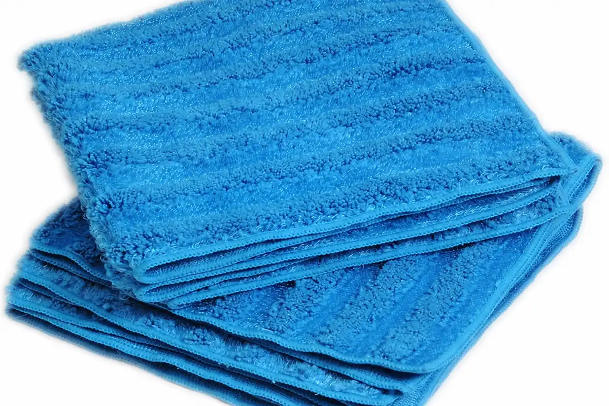 High-resolution stack of blue microfiber towels showing complete cloth shape, loop pile and stitched edging for wholesale textile review