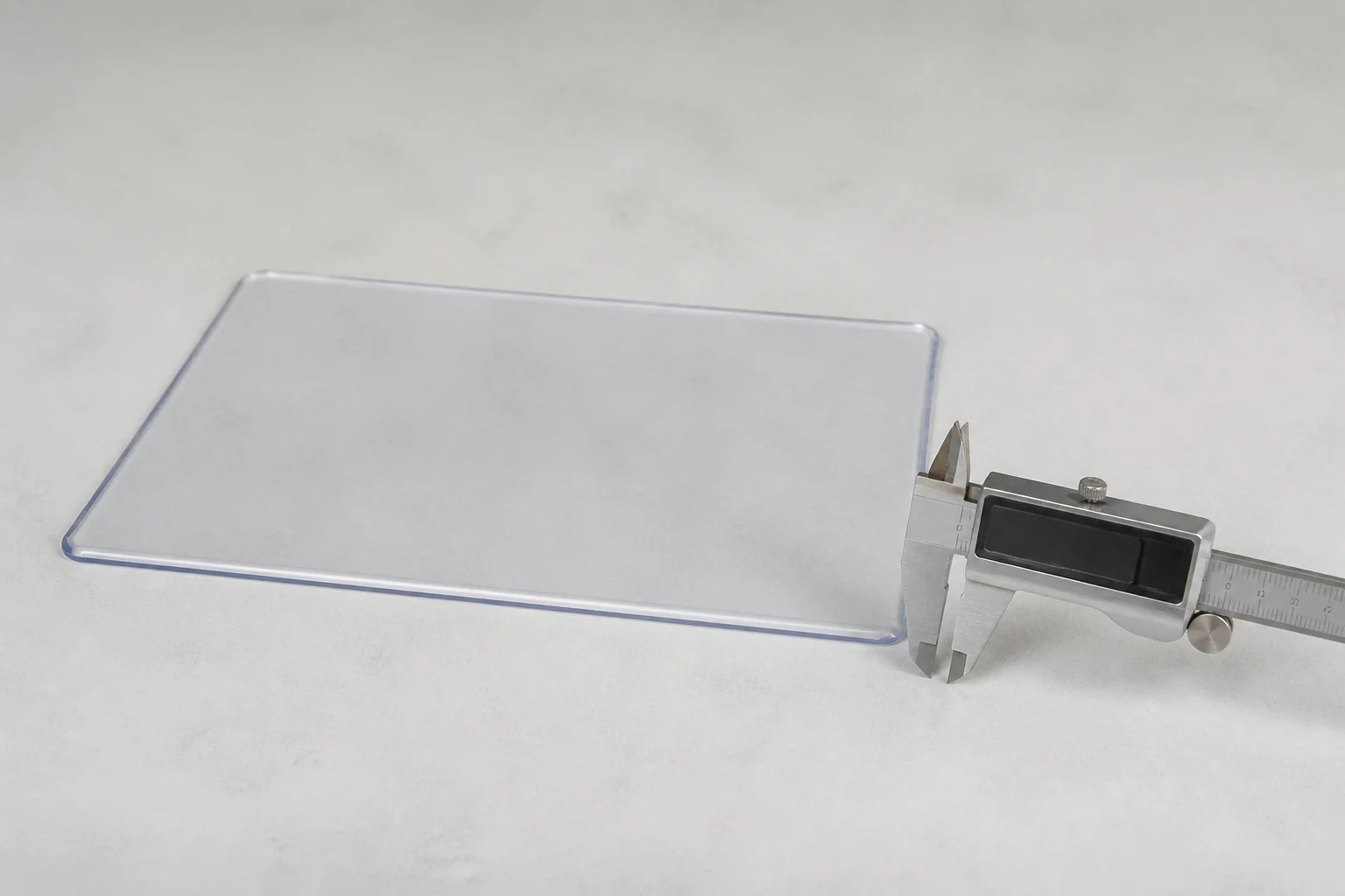 A complete clear sample and unbranded caliper illustrate why the measurement method belongs in the specification.