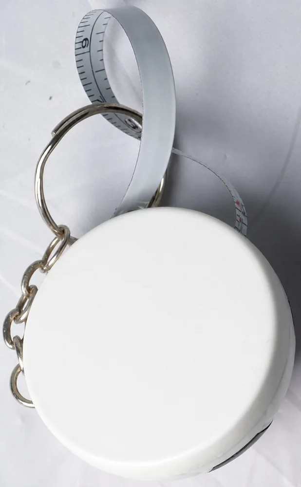Complete white round mini tape measure keychain with flexible tape loop metal rings and clip