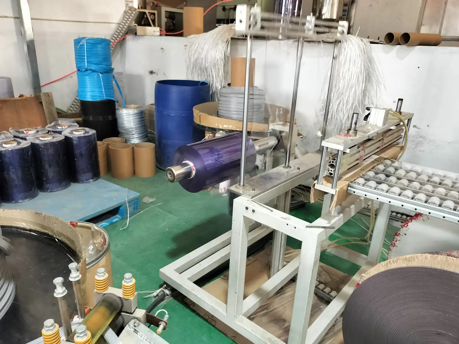 Flexible PVC roll staged on processing equipment in a production area.